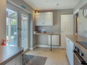 a kitchen with white cabinets and a counter top at Goose Green Cottage in Snettisham