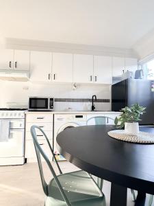 a kitchen with a black table and chairs in it at Mi Casa Su Casa - 2BR Sleeps 6 - Free Parking - CBD in Brisbane