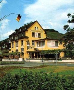 uma grande casa amarela com um papagaio a voar no ar em Hotel Café Post em Rüdesheim am Rhein