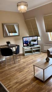 a living room with a table and a tv at Bewick Apartments in Newcastle upon Tyne +6 photos