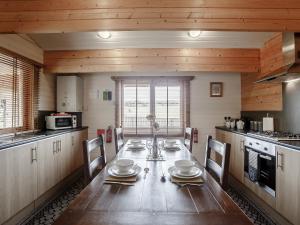 a kitchen with a wooden table with chairs and a tableasteryasteryasteryasteryastery at Jessica in Edrom