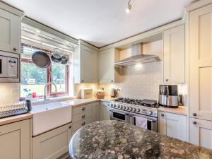 a kitchen with white cabinets and a counter top at Egmont Farmhouse in Newenden +15 photos