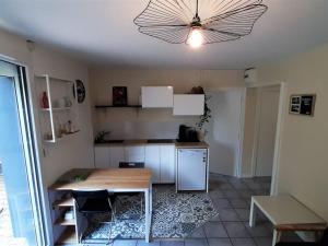 una cucina con tavolo, tavolo e soffitto di Gîte "Le temps d'une pause" terrasse et piscine a Coubon