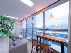 ソウルにあるGasan Daylight Houseのテーブルと椅子と大きな窓のある部屋