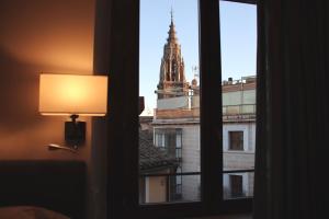 a room with a window with a view of a tower at San Ginés Rooms Self Check-In in Toledo