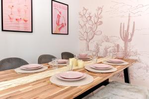 a dining room table with pink dishes on it at Seafront apartment in Bognor Regis