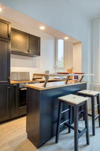 cocina con encimera azul y taburetes en The Flaubert accommodation with parking in the heart of the city center, en Rouen