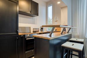 Una cocina con una encimera con una copa de vino encima. en The Flaubert accommodation with parking in the heart of the city center, en Rouen