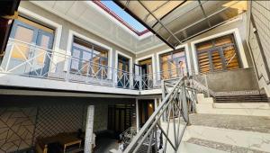 a person standing on the balcony of a house at Guesthouse Anora 1, Three minutes walk from Registan Square, The very Center of Samarkand in Samarkand +22 photos