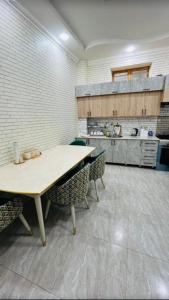 a kitchen with two tables and chairs in a room at Guesthouse Anora 1, Three minutes walk from Registan Square, The very Center of Samarkand in Samarkand