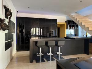 a kitchen with a black counter and a staircase at Pommard Clos in Pommard