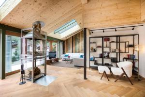 a living room with wood ceilings and a living room with a ladder at Face D'or Luxury Serviced Apartments in Zermatt