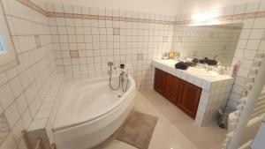 een witte badkamer met een bad en een wastafel bij Dépendance cocooning bon standing Ampuis in Ampuis