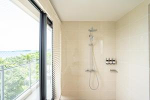 a bathroom with a shower with a window at TIMeSCAPE -tancha- in Onna +32 photos