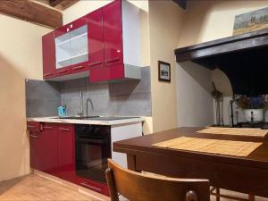 a kitchen with red cabinets and a counter top at Ultimo Piano in Murlo