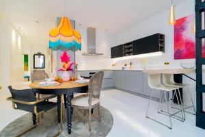 a kitchen with a dining table with chairs and a colorful ceiling at Luxury Golden Apartamento a solo pasos de Gran Vía in Madrid +24 photos