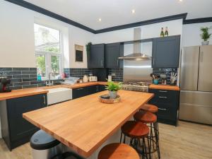 Una cocina con una mesa de madera y un refrigerador. en 11 Bronte Street, en Haworth