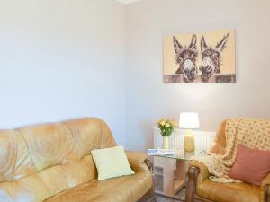 ein Wohnzimmer mit Sofa und Tisch in der Unterkunft Ardlochan Cottage in Maidens