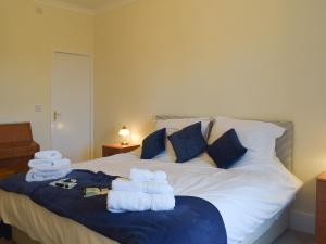ein Schlafzimmer mit einem Bett mit Handtüchern darauf in der Unterkunft Ardlochan Cottage in Maidens