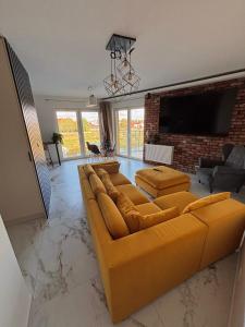 a living room with a couch and a tv at Apartament nad Wartą Śrem in Śrem
