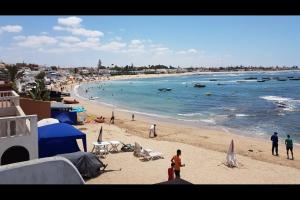 una playa con un grupo de personas en el agua en Mansouria 1BR Pool View Beach Parking, en Minaret de Mansuria