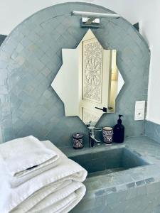 a bathroom with a sink with towels and a mirror at Riad Dar Elif in Tangier +64 photos