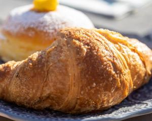two pastries sitting on a plate on a table at Aria Life Hotel Pinzolo in Pinzolo +14 photos
