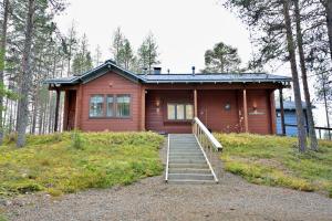 una casa con una escalera al frente en Holiday Cabin Isomus inc outdoor jacuzzi, en Äkäslompolo