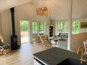 a living room with a couch and a table at Lovely Black Wooden House Near Tisvilde Hegn in Tisvilde