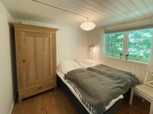 a bedroom with a bed and a large window at Lovely Black Wooden House Near Tisvilde Hegn in Tisvilde