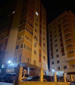 two tall buildings next to each other at night at Relaxing 2 beds Apartment, Quiet & Comfortable in Chişinău