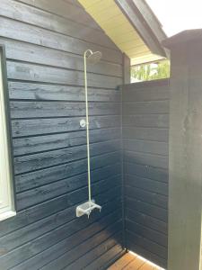 a shower in a bathroom with a blue wall at Lovely Black Wooden House Near Tisvilde Hegn in Tisvilde