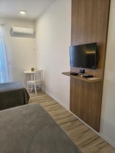 a hotel room with a flat screen tv on a wall at Hotel Porto de Paz - Shantiniketan in São Francisco do Sul