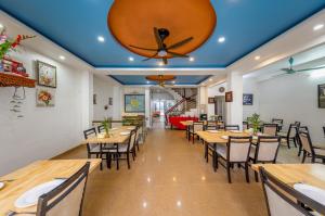 a restaurant with wooden tables and chairs and a ceiling at Hưng Ha Hotel in Cat Ba