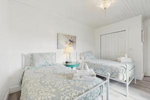 a white bedroom with a bed and a chair at Sassafras Cottage in Waynesville