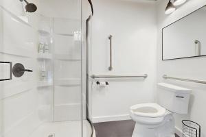 a white bathroom with a shower and a toilet at Sassafras Cottage in Waynesville +20 photos
