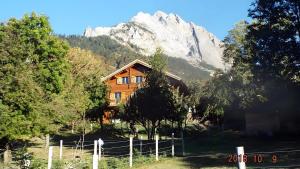 a wooden house in front of a mountain at Chambres D'hôtes Barnabas in Beaune
