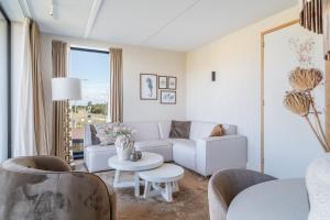a living room with a couch and a table at Residence Westduin in Sint Maartensvlotbrug +1 photo