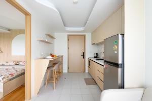 a small kitchen with a refrigerator and a bed at Fantasea Condo Kamala B502 1BDRM by Phuket Sabay Rent in Kamala Beach