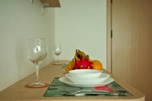 a table with a plate of fruit and a glass of wine at Fantasea Condo Kamala B502 1BDRM by Phuket Sabay Rent in Kamala Beach +31 photos