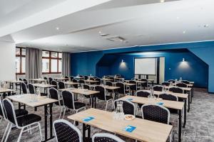 a room with tables and chairs and a projection screen at Rodzinne Resorty Karkonosze in Wojcieszyce +77 photos