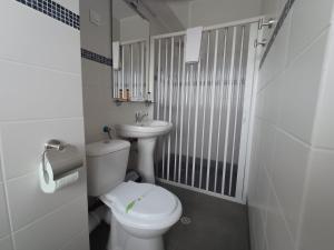 a white bathroom with a toilet and a sink at G Residence in Ploieşti