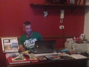 um homem sentado numa mesa com um computador portátil em Villa Malandrino Guest House em Agropoli