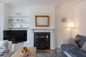 a living room with a couch and a television at Sole Rose in Southwold