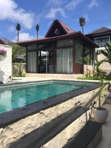 una piscina frente a una casa en Ocean Bay Retreat, en Bingin Beach