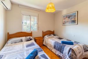 a bedroom with two beds and a chandelier at Villa Pilara - Brunete in Brunete +35 photos