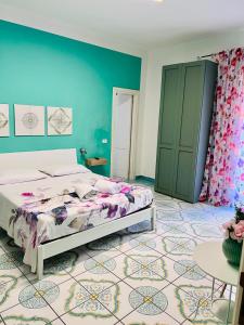 a bedroom with a bed and a blue wall at Villa Lery - Azzurra Home in Agropoli
