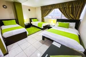 a hotel room with two beds and a window at Hotel Las Gardenias in Cuenca