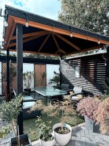 a pavilion with a table and chairs in a garden at The Cabin at the Orchard House- Stricly No Parties in Barton in the Clay