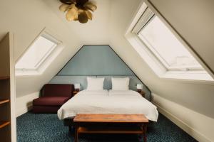 a bedroom with a bed and a red chair at Hôtel Folie - Orso Hotels in Paris